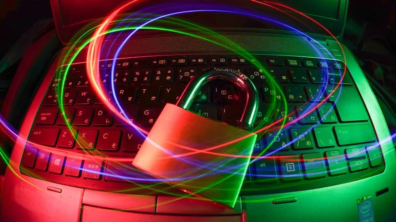Laptop keyboard illuminated with colorful light trails, representing secure streaming setup
